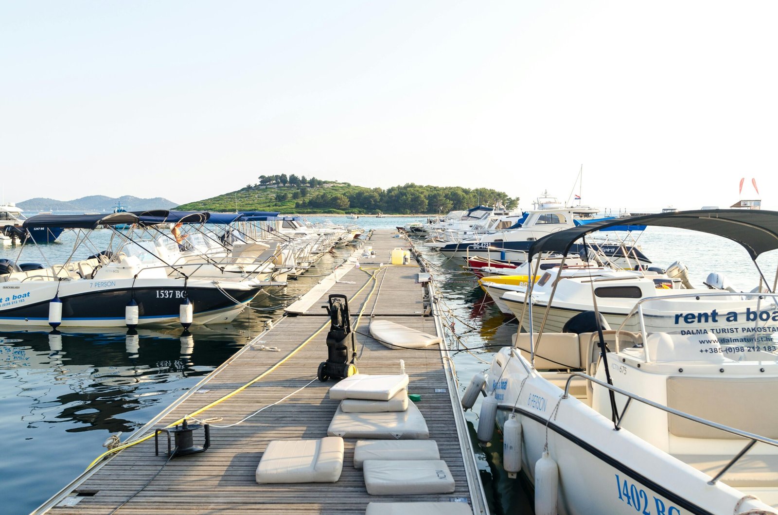 Explore a tranquil Croatian harbor with moored boats and yachts on a sunny day.