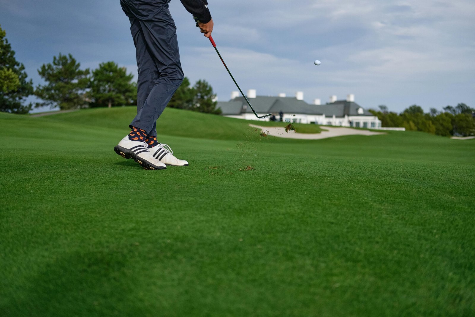 A golfer mid-swing on a beautiful green golf course in Oberwaltersdorf, Austria.